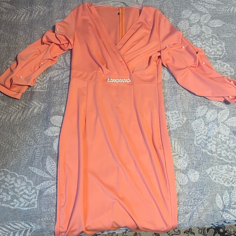 Peach dress with pearls on the arm of each sleeve and at the stomach area
